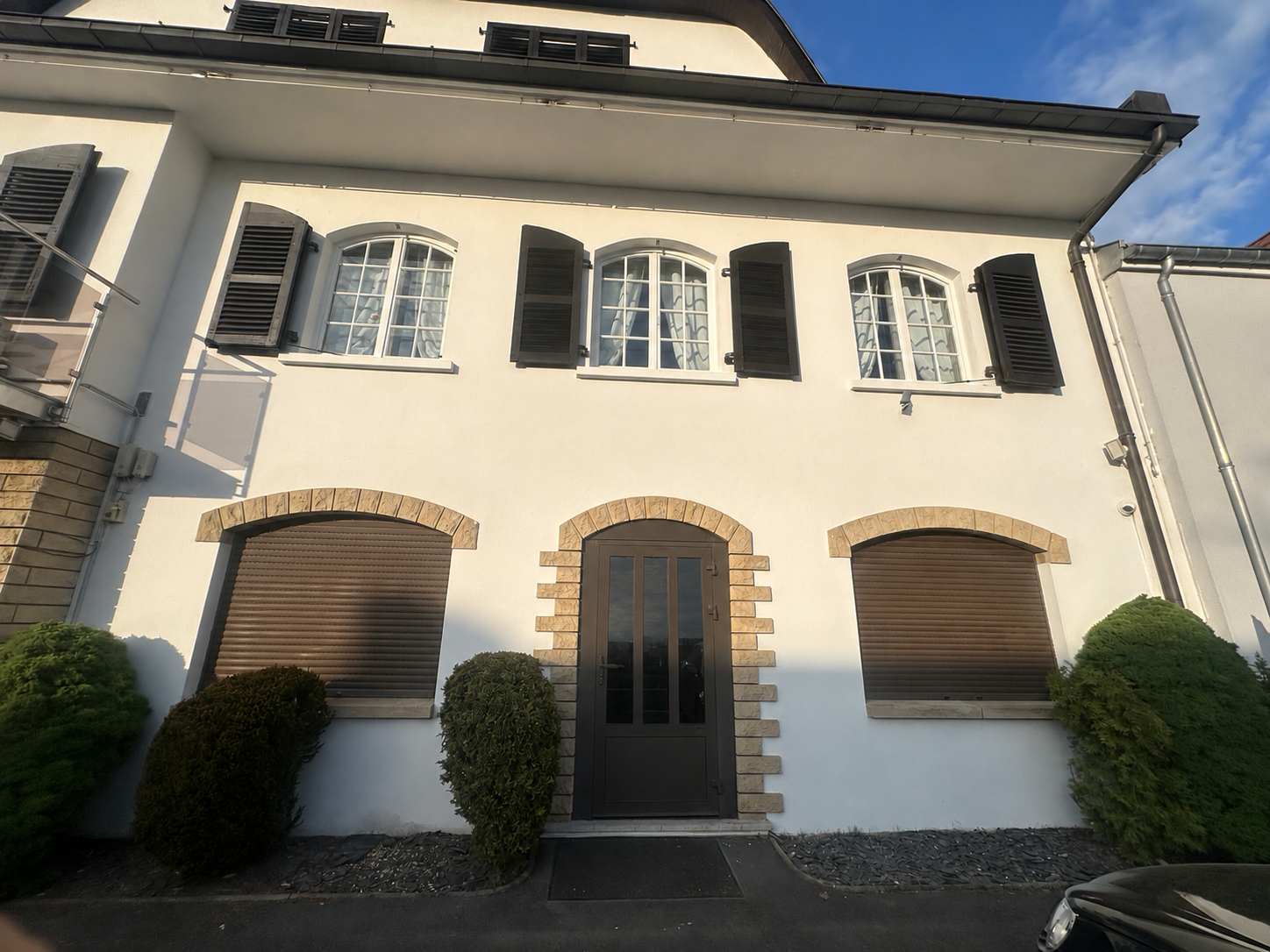 Façade de Studio Sorella 57 à Hettange-Grande, architecture épurée à trois portes cintrées